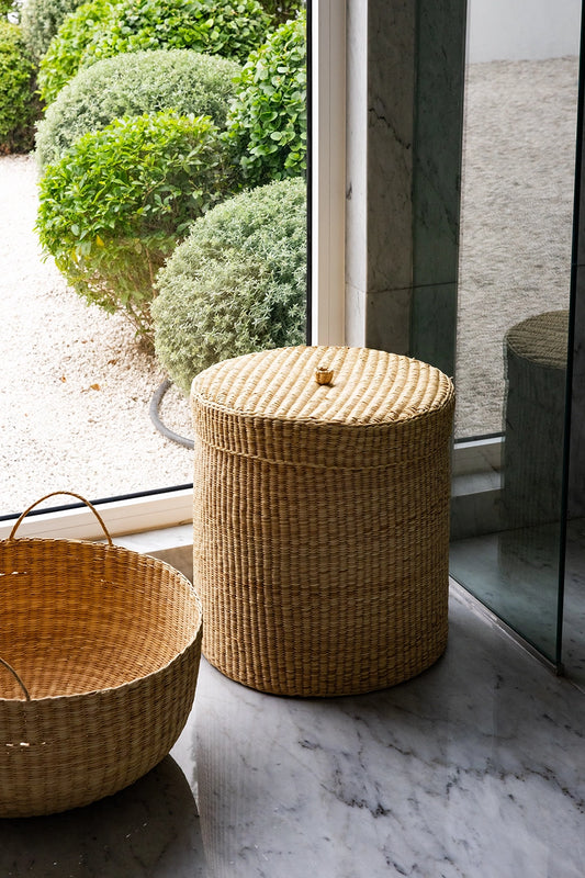 Woven baskets on a marble floor with a glass door in the background