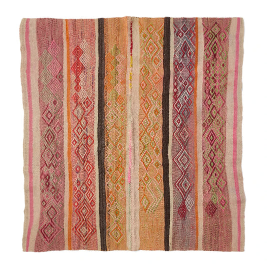 A square woven kilim rug with vertical stripes and diamond geometric patterns in pink, orange, brown, beige, and red, shown flat against a white background.