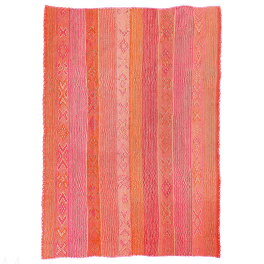 Folded pink and orange patterned frazada on a white background