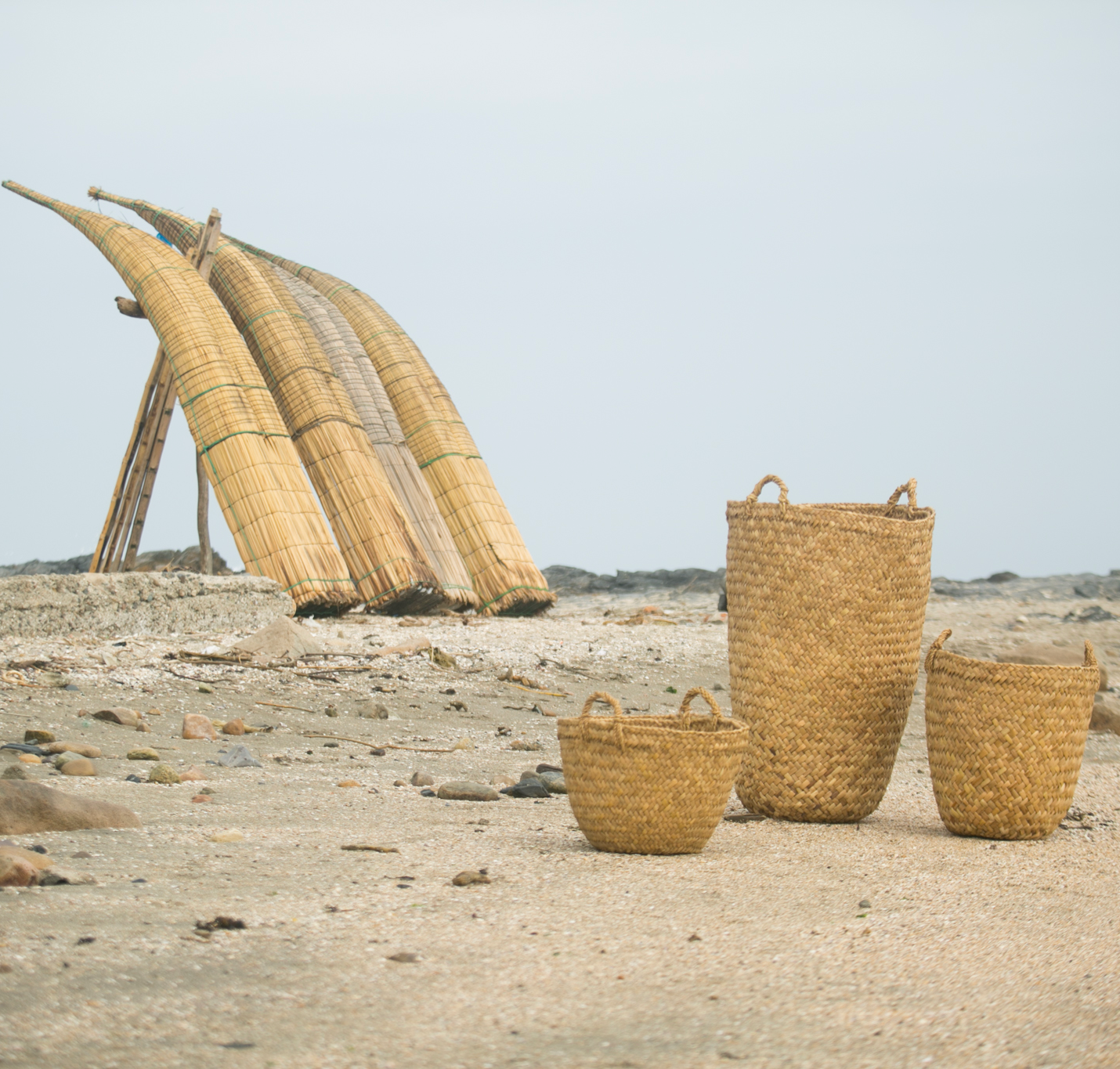 Intiearth woven tototora basket with totora reed boats on beach