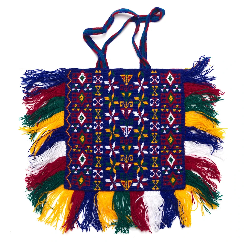 Colorful hand-woven bag with intricate patterns and fringes on a white background