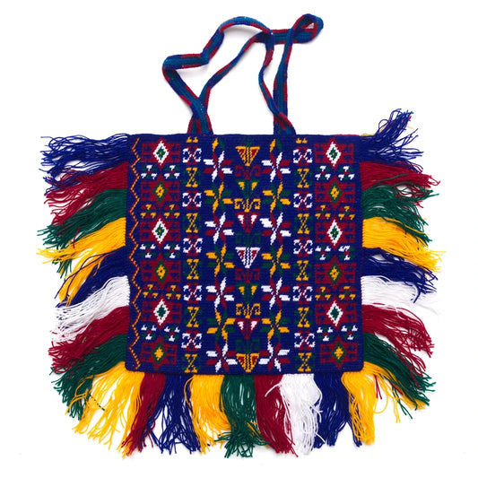 Colorful hand-woven bag with intricate patterns and fringes on a white background
