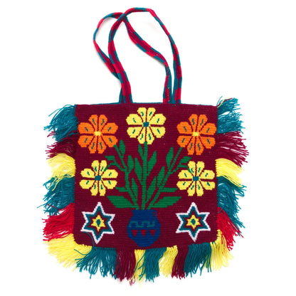 Colorful handbag with floral patterns and fringes on a white background