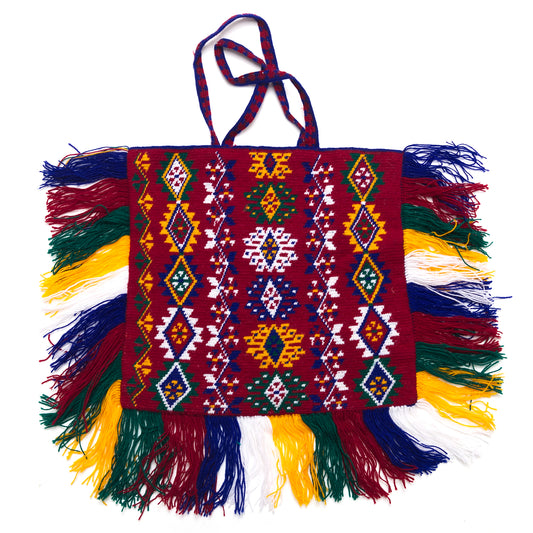 Colorful handbag with intricate patterns and fringes on a white background