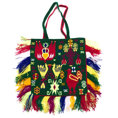 Colorful handbag with intricate patterns and fringes on a white background