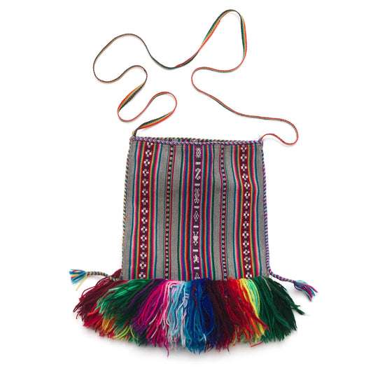 Colorful handbag with patterned strap and fringe on a white background