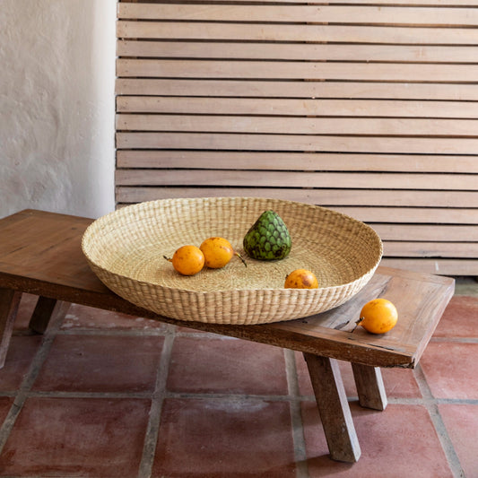 Intiearth Handwoven oversized basket platter made of natural fibers, ideal as a serving dish or decorative centerpiece on stool