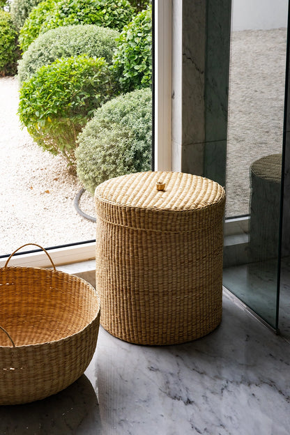 Woven baskets on a marble floor with a glass door in the background