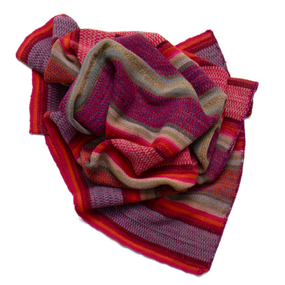 Striped knitted blanket in red, purple, and brown on a white background