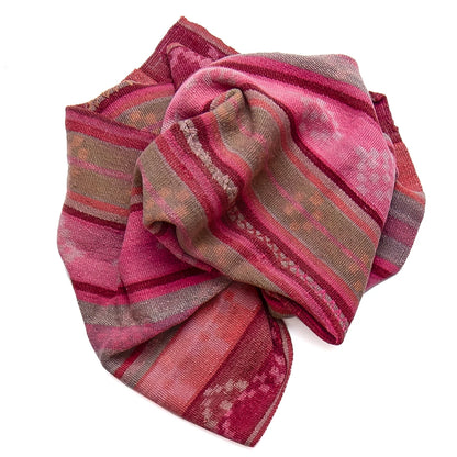 A folded patterned scarf in shades of pink, red, and brown with woven geometric stripes, shown on a plain white background.