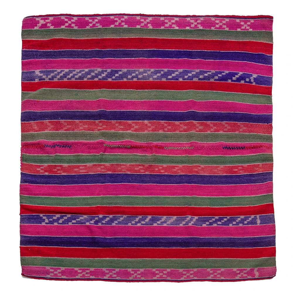 A square woven textile with horizontal stripes in bright pink, red, purple, and olive green, featuring geometric and diamond patterns along the borders, shown flat against a white background.