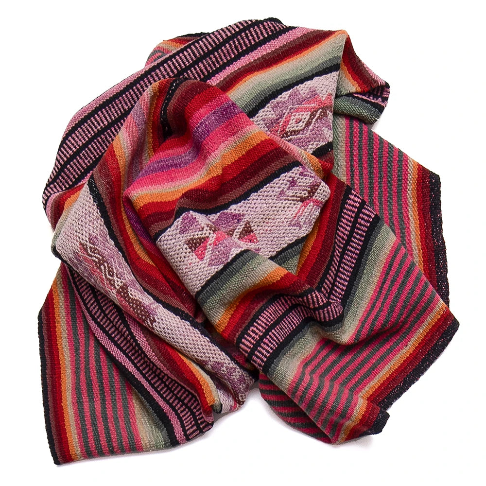 A multicolor striped knit blanket with geometric patterns, featuring shades of red, pink, orange, green, and black, arranged on a plain white background.