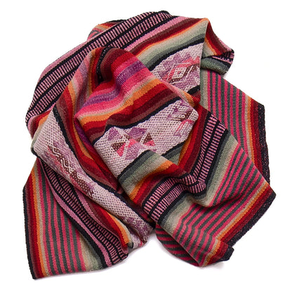 A multicolor striped knit blanket with geometric patterns, featuring shades of red, pink, orange, green, and black, arranged on a plain white background.