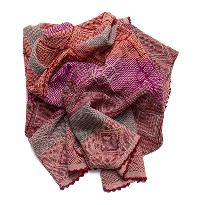 Folded patterned fabric with pink, red, and brown colors on a white background