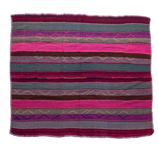 A square woven textile with horizontal stripes in pink, teal, purple, brown, and gray, featuring geometric diamond patterns and a fringed border, shown flat against a white background.