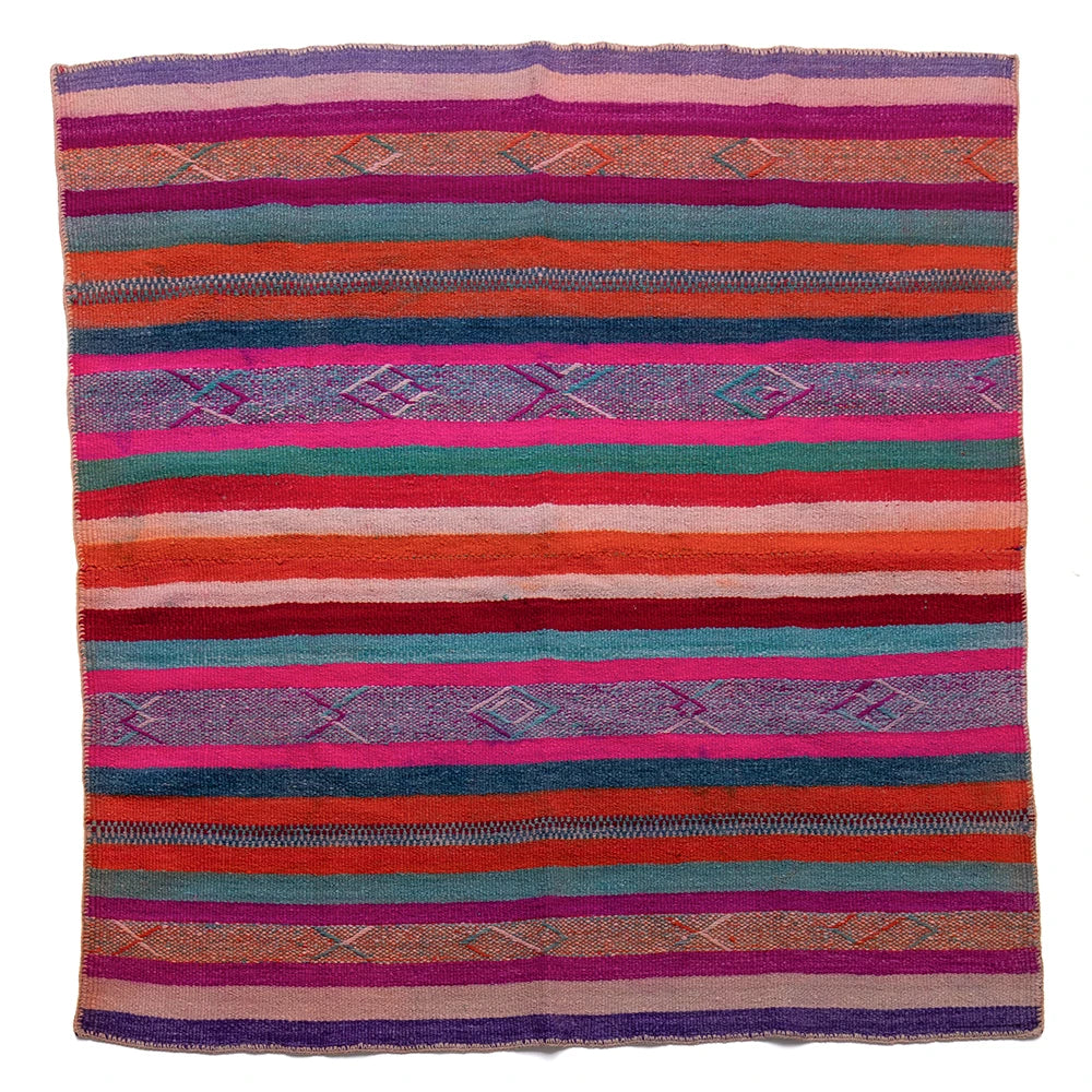 Colorful striped woven blanket with geometric patterns on a white background