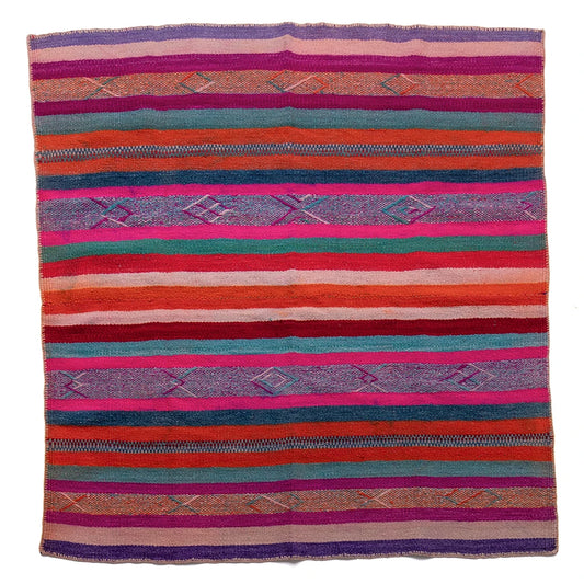 Colorful striped woven blanket with geometric patterns on a white background