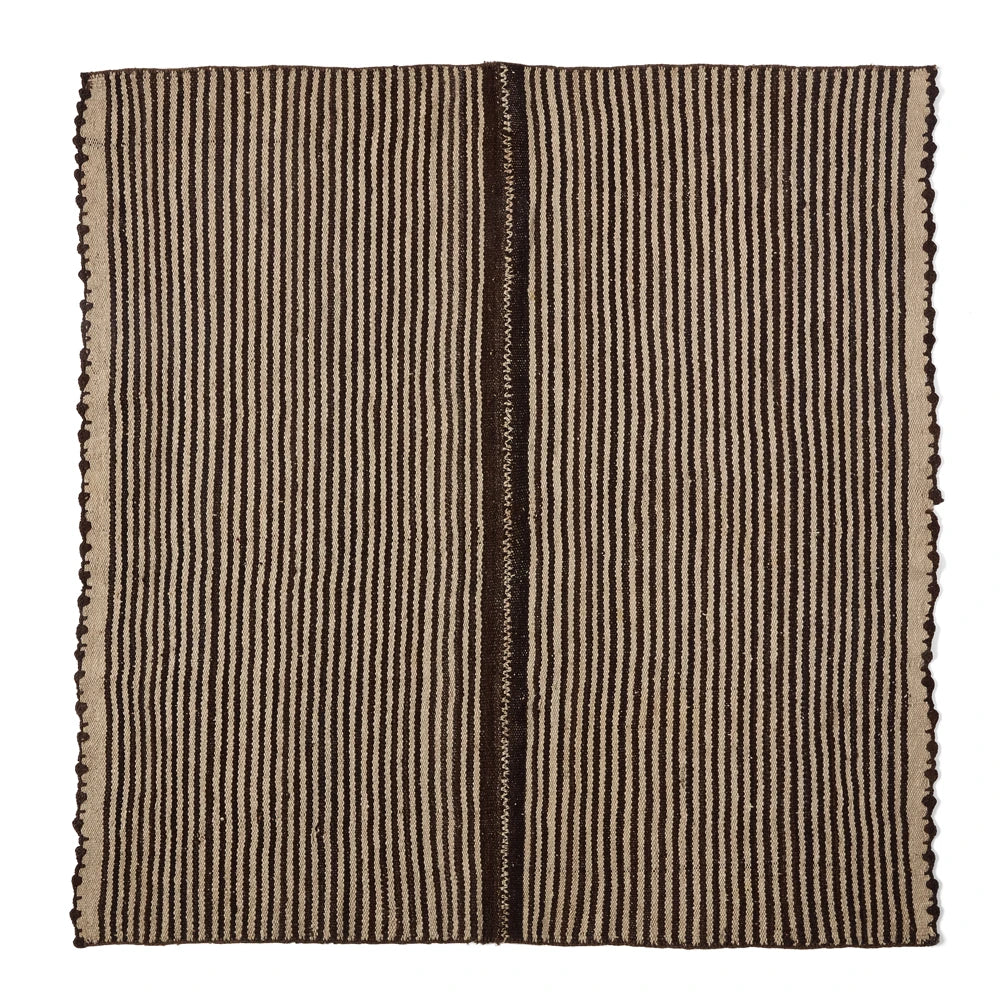 A square woven textile or rug with a vertical striped pattern in dark brown and beige, featuring fringed edges on all sides, shown flat against a white background.