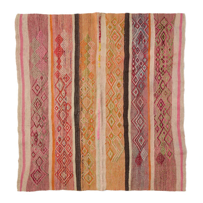 A square woven kilim rug with vertical stripes and diamond geometric patterns in pink, orange, brown, beige, and red, shown flat against a white background.