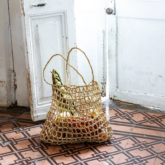 Woven bag on a patterned floor with white doors in the background