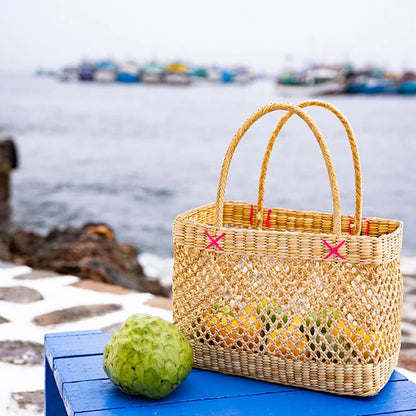 Woven bag with colorful handles on a blue bench by a waterfront