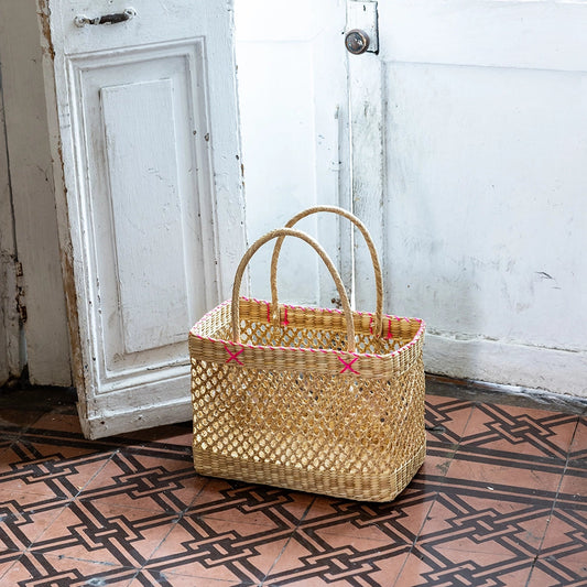 Intiearth Pucu Woven basket on a patterned floor with a white door in the background