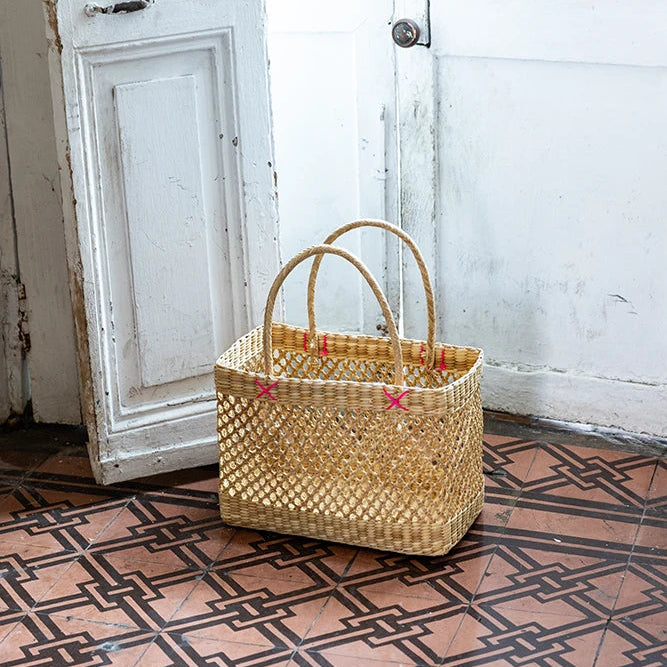 Woven basket on a patterned floor with a white door in the background