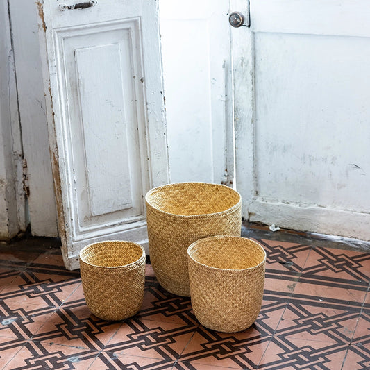 Intiearth Puno Three woven baskets on a patterned floor with a white door in the background