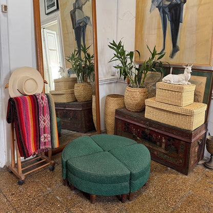 Room interior with a large mirror, ottoman, woven basket storage boxes stacked, and decorative items.