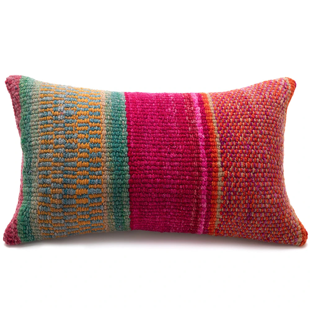 A rectangular handwoven lumbar pillow featuring vertical stripes of teal green, bright magenta pink, and orange-red with subtle multicolored yarn texture, shown on a plain white background.
