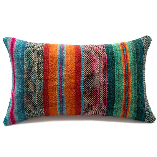 A rectangular lumbar throw pillow with a vibrant, multicolored serape-style striped pattern, featuring vertical bands of teal, orange, red, pink, and green on a clean white background.