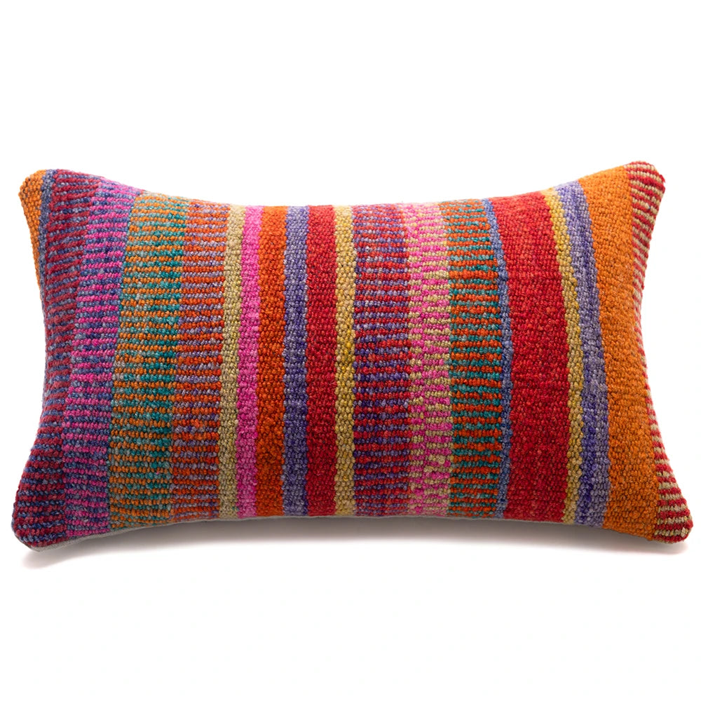 A rectangular lumbar throw pillow with a vibrant, multicolored striped pattern featuring vertical bands of red, orange, pink, purple, blue, and gold on a white background.
