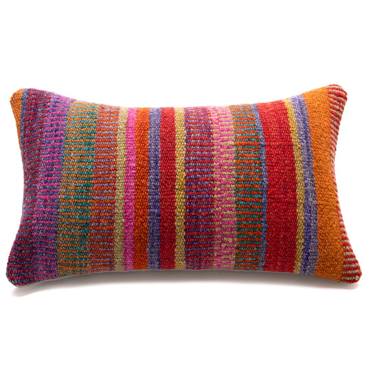 A rectangular lumbar throw pillow with a vibrant, multicolored striped pattern featuring vertical bands of red, orange, pink, purple, blue, and gold on a white background.