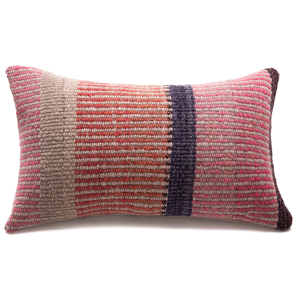 A rectangular woven throw pillow with a striped pattern in pink, terracotta, beige, and dark purple, shown on a plain white background.