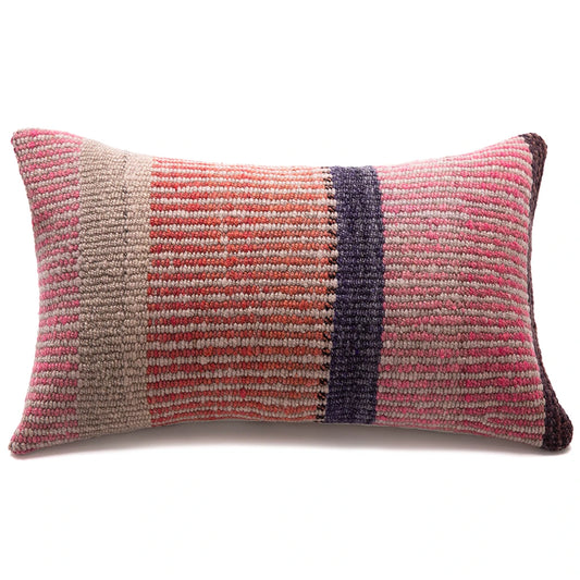 A rectangular woven throw pillow with a striped pattern in pink, terracotta, beige, and dark purple, shown on a plain white background.