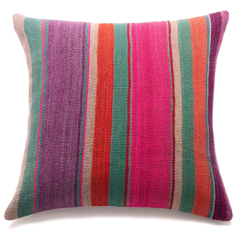 A square throw pillow with a textured, woven fabric featuring vertical stripes in purple, teal green, orange, pink, and beige, set against a plain white background.