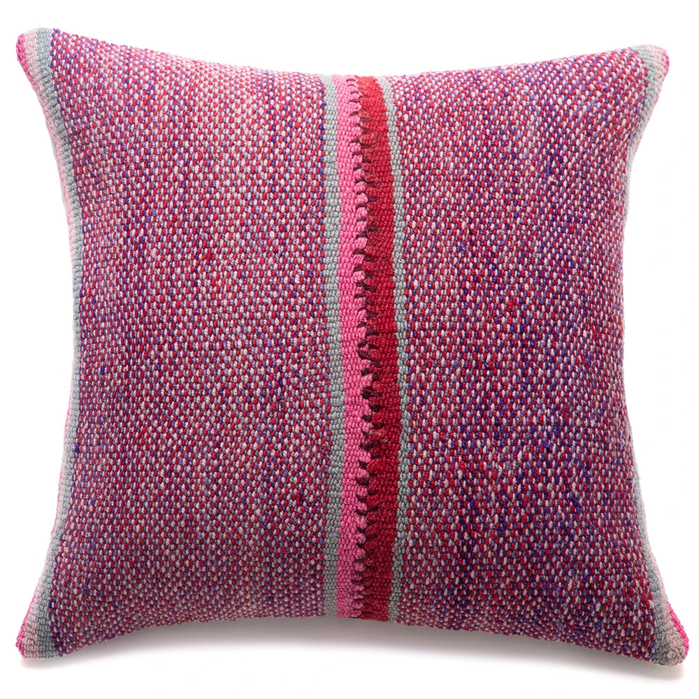 A square woven throw pillow featuring a textured multicolor pattern of pink, red, purple, and blue threads, with a prominent vertical red stripe down the center and a gray border.