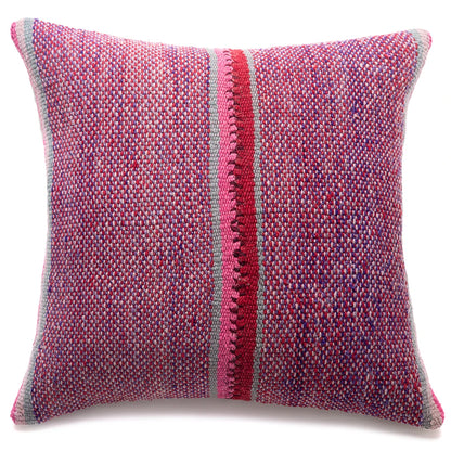 A square woven throw pillow featuring a textured multicolor pattern of pink, red, purple, and blue threads, with a prominent vertical red stripe down the center and a gray border.
