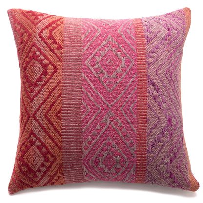 Decorative pillow with geometric pattern in pink and red on a white background