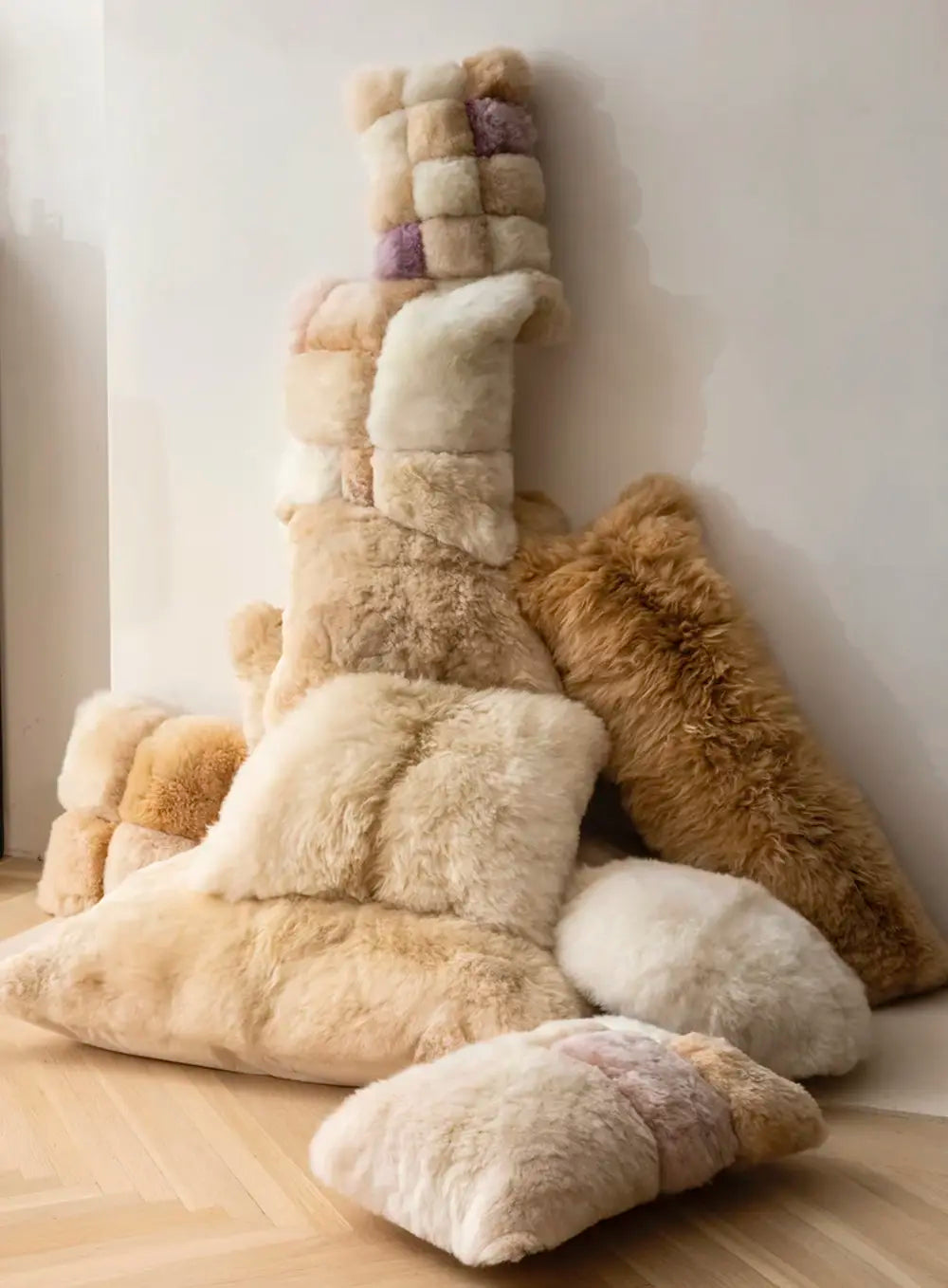 Alpaca Pillows stacked on wood floor