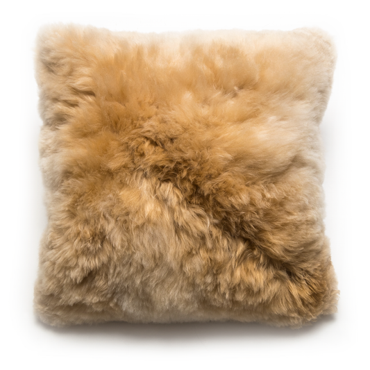 A square-shaped alpaca fur  pillow with a zipper closure, displaying a natural champagne color.