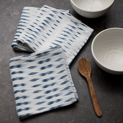 Folded White and Blue Ikat Napkins on black stone table